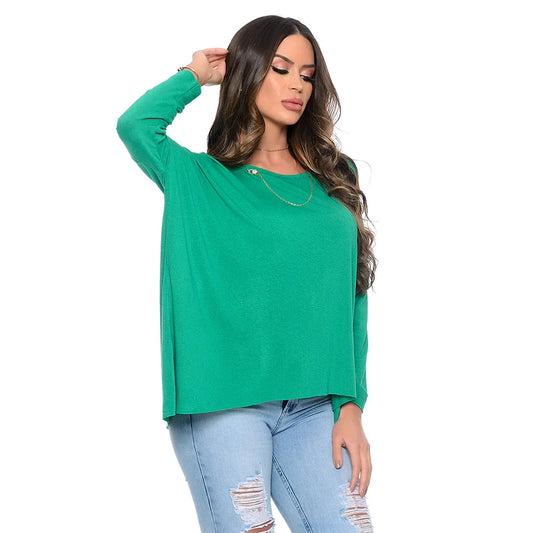 Mulher usando blusa verde de manga longa com calça jeans clara rasgada, fundo branco