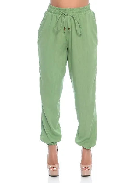 Calça feminina verde clara, estilo jogging com cós elástico e cadarço, usada com salto alto nude