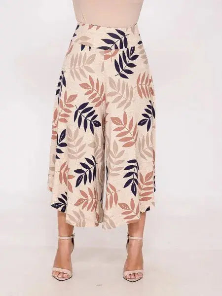 Calça pantacourt feminina bege com estampa de folhas em azul, marrom e bege, combinada com sandálias de salto