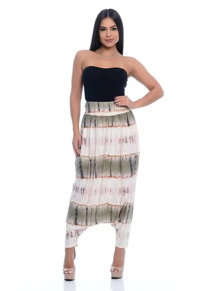 Mulher com vestido longo tomara que caia preto e saia estampada em tons neutros, posando em fundo branco